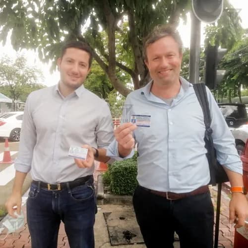 Two friends showing their new Thai driving licenses outdoors