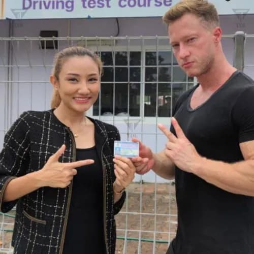 Happy couple at the driving school after passing their test
