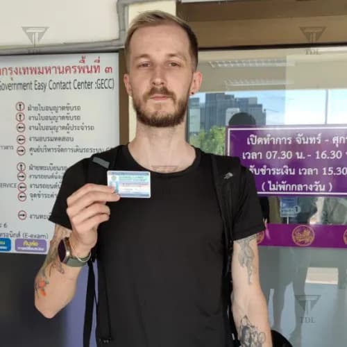 Young client proudly holding his Thai driving license at DLT office
